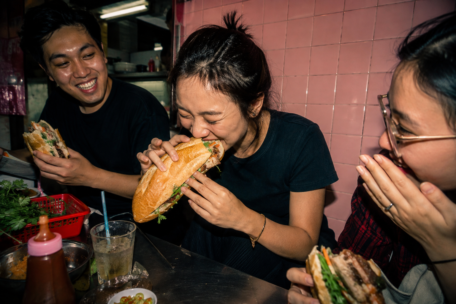 Friends sharing bánh mì at a lively Saigon counter